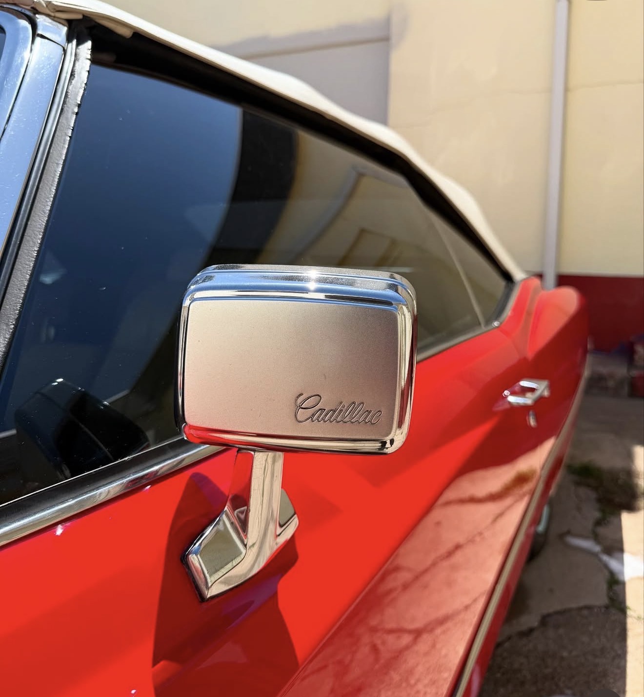 Polished chrome mirror on a red Cadillac